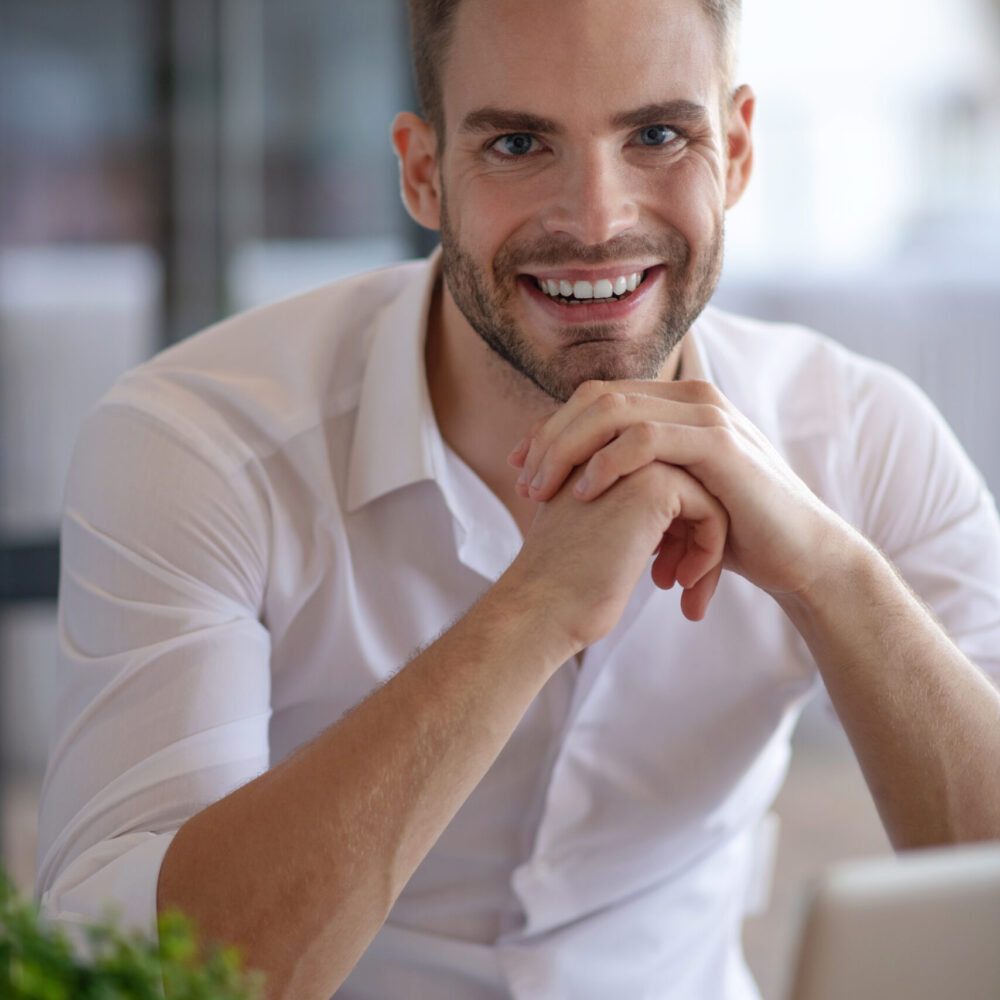 Young handsome businessman in a white shirt smiling nicely Working. Young handsome businessman in a white shirt smiling nicely